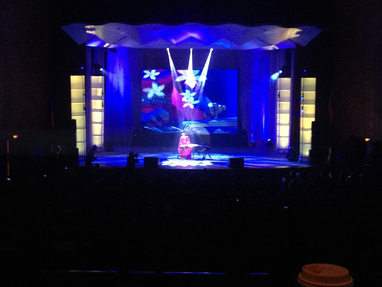 Theatre stage with deep blue lighting and sharply aimed white effects